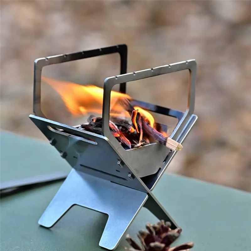 Portable metal stove with flames on a blurred natural background
