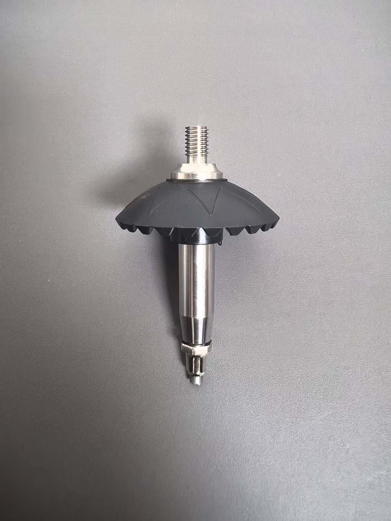 A metal and rubber ground sleeve or auger tip with a dark gray rubber cone and a silver threaded metal shaft, shown against a plain gray background.